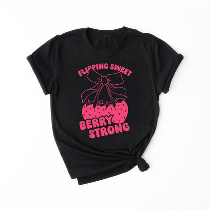 Black t-shirt with red strawberry bow graphic and text that says “Flipping Sweet, Berry Strong” – gymnast shirt design.